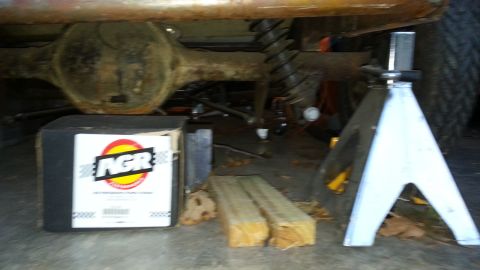 2005 Ford Mustang - The rear axle and suspension components of a vehicle are visible, supported by jack stands and a box.
