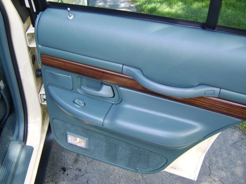 1996 Mercury Grand Marquis - Interior door panel detail, likely from a 1995 Mercury Grand Marquis, showing blue vinyl and wood trim.