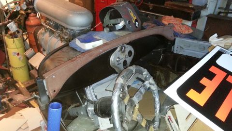 2005 Ford Mustang - A cluttered garage scene shows a car's interior and engine components alongside tools and a welding mask.