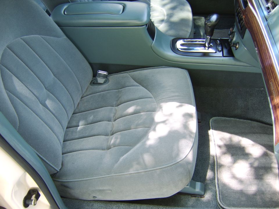 Gray cloth front passenger seat, console shifter and woodgrain trim in a sedan