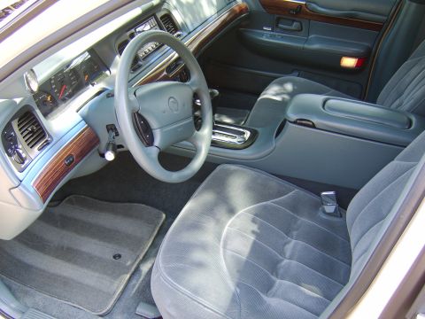 1996 Mercury Grand Marquis - The interior of a car shows the dashboard, steering wheel, and front seats with a center console.