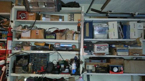 2005 Ford Mustang - A cluttered garage scene with shelves holding various items and storage boxes.