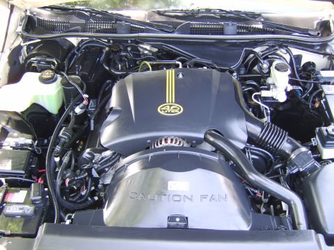1996 Mercury Grand Marquis - Engine bay detail the 4.6 liter badge and a prominent "CAUTION FAN" warning.