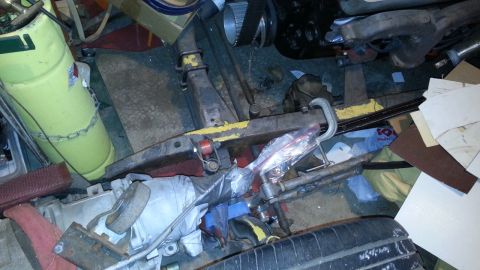 2005 Ford Mustang - A disorganized garage space filled with various automotive parts and equipment.