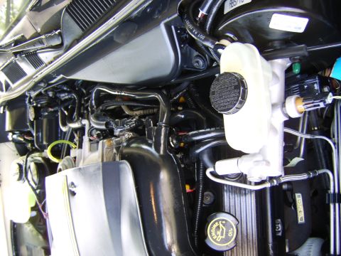 1996 Mercury Grand Marquis - A close-up view of a car's engine bay, showing various components and hoses.