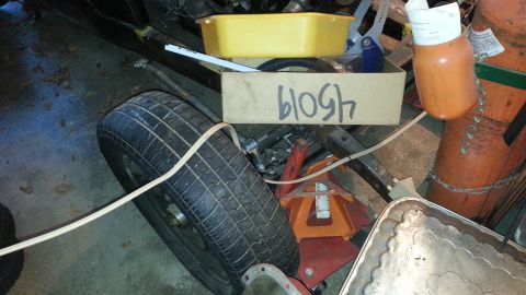 2005 Ford Mustang - A collection of items, including a tire and a gas tank, are stored in a garage setting.