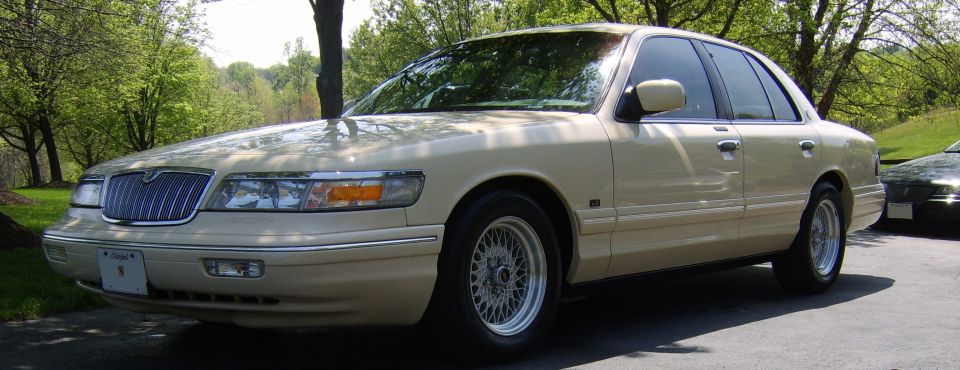 Cream Mercury Grand Marquis sedan on mesh alloy wheels, front three-quarter