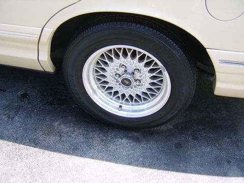 1996 Mercury Grand Marquis - A close-up of the rear wheel and fender of a 1996 Mercury Grand Marquis.