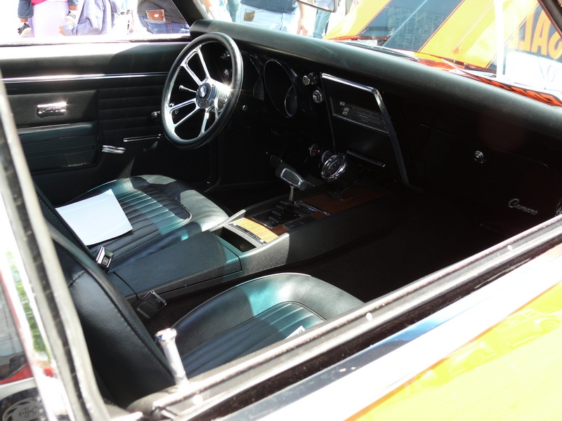 1968 Chevrolet Camaro interior with black seats, wood trim, and a chrome steering wheel