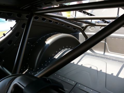 1968 Chevrolet Camaro - The interior of a vehicle shows a custom roll cage and modified rear wheel well, with a watermark at the bottom.