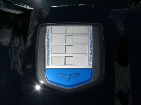 1968 Chevrolet Camaro - Close-up of a vehicle's engine cover displaying 'LS9 SUPERCHARGED' text and a blue Corvette emblem.