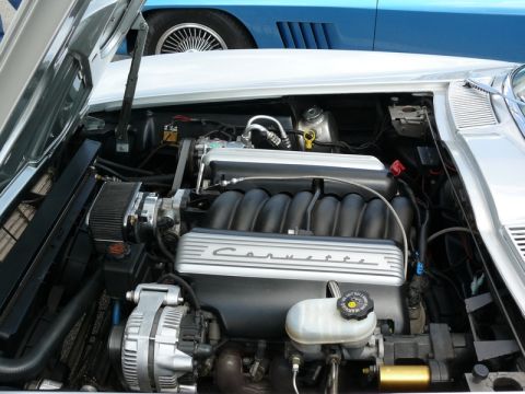 1968 Chevrolet Camaro - Close-up of a Corvette engine bay, with another blue vehicle visible behind it.