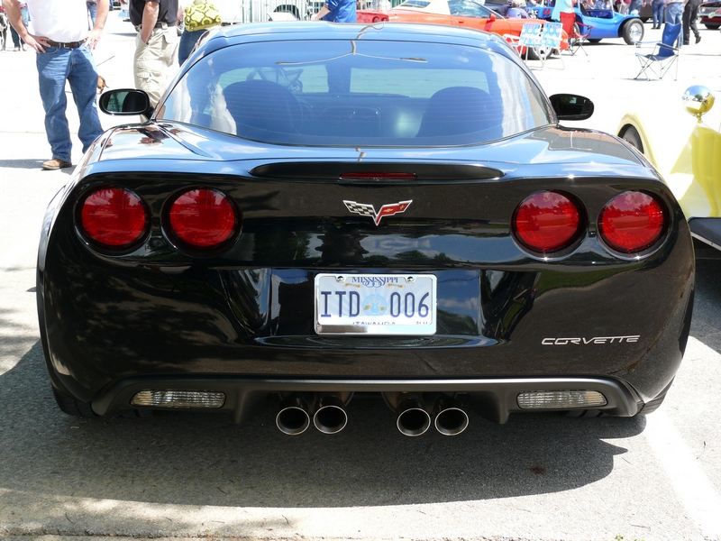 Black Chevrolet Corvette rear with quad exhaust pipes and "CORVETTE" badging
