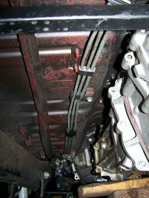 1988 Suzuki Samurai - Close-up of brake lines and transmission components visible from the underside of a vehicle.
