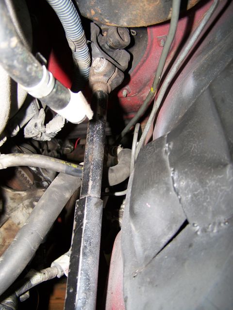 1988 Suzuki Samurai - Close-up view of engine components, including a driveshaft and hoses, with a red engine block visible.