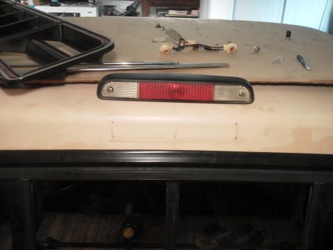 1979 Ford F-150 - Third brake light assembly and trim piece on a surface, possibly a vehicle roof.