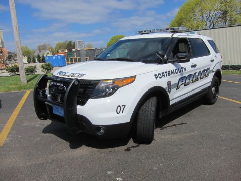 1991 Ford LTD Crown Victoria - white Portsmouth Police SUV marked 07 with a heavy front pushbar and roof light bar parked in a paved lot.