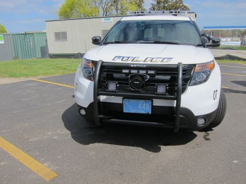 1991 Ford LTD Crown Victoria - Front view of a white POLICE SUV with a black pushbar, mounted camera and Setina equipment, license plate ending 448.