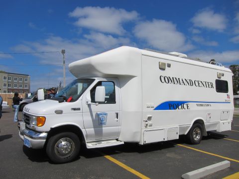 1991 Ford LTD Crown Victoria - white police Command Center motorhome marked POLICE Middletown with a blue stripe parked in a paved lot under blue sky.