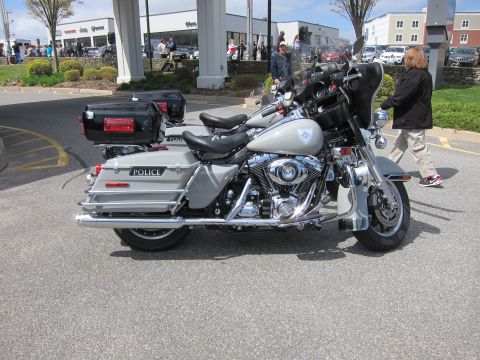 1991 Ford LTD Crown Victoria - silver Harley-Davidson police touring motorcycle equipped with hard saddlebags and a rear top case parked at an outdoor event.