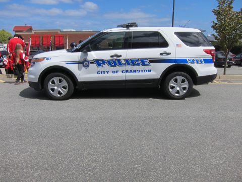 1991 Ford LTD Crown Victoria - white City of Cranston Police Ford Explorer SUV with blue stripes shown from the side near a brick building.