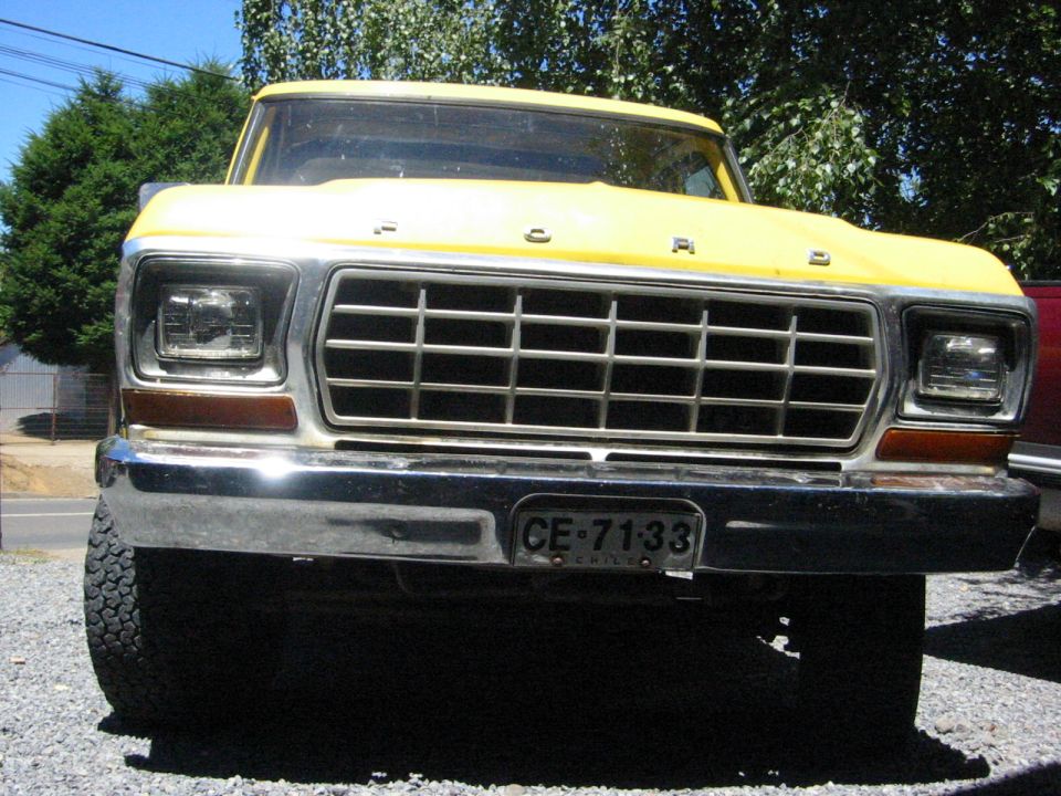 Front view of a yellow Ford truck with a chrome grille and bumper. License plate reads CE 71-33