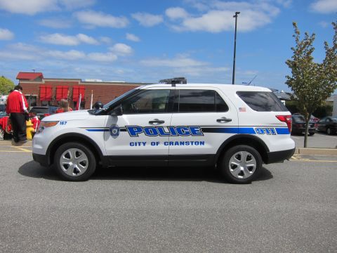 1991 Ford LTD Crown Victoria - white City of Cranston Police Ford Explorer SUV parked in a lot, shown in side profile under a partly cloudy sky.
