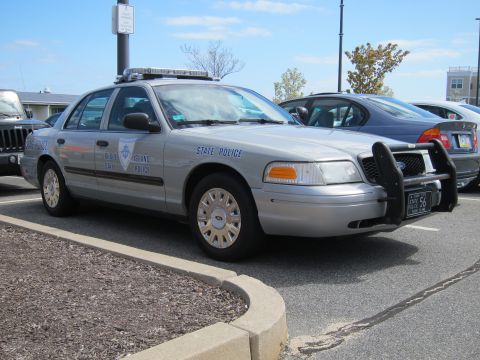1991 Ford LTD Crown Victoria - silver State Police Ford Crown Victoria sedan fitted with a front push bar, parked at the edge of a lot beside other vehicles.