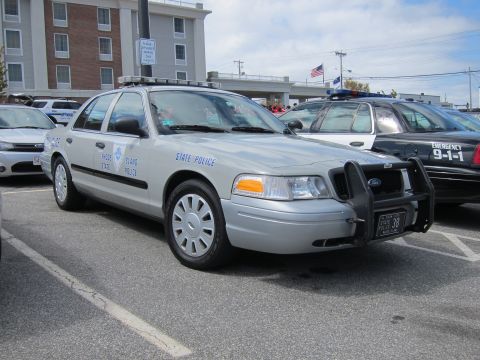 1991 Ford LTD Crown Victoria - silver Rhode Island State Police Ford Crown Victoria with a front push bar parked among other cruisers near a hotel.