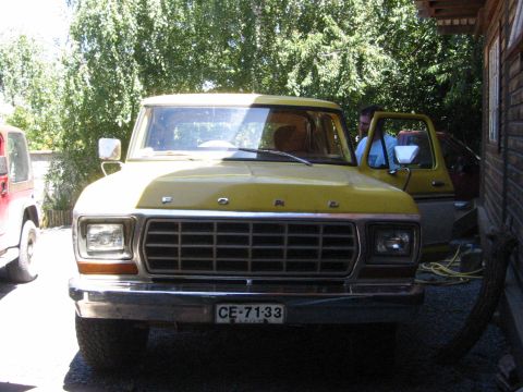 1979 Ford Bronco - Front view of a yellow 1979 Ford Bronco with its driver's door open, parked beside a red Jeep.