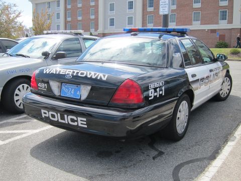1991 Ford LTD Crown Victoria - black-and-white Watertown Police Ford Crown Victoria cruiser shown from the rear quarter with Emergency 9-1-1 markings.