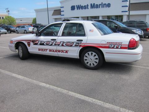 1991 Ford LTD Crown Victoria - white West Warwick Police Ford Crown Victoria cruiser with red and black striping parked in a lot outside a West Marine store.