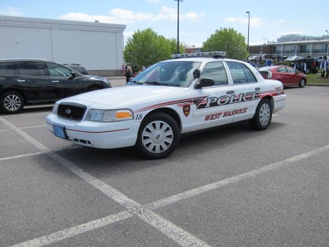 1991 Ford LTD Crown Victoria - Front three-quarter view of a white West Warwick Police Ford Crown Victoria, unit 18, with light bar parked in a lot.