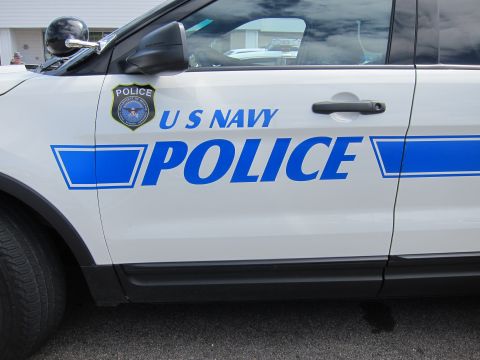 1991 Ford LTD Crown Victoria - Close-up of the front door of a white U S NAVY POLICE Ford Explorer showing blue lettering and a police emblem.