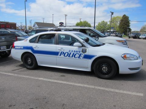 1991 Ford LTD Crown Victoria - Side profile of a white U S NAVY POLICE Chevrolet Impala with blue striping, light bar, and black steel wheels.