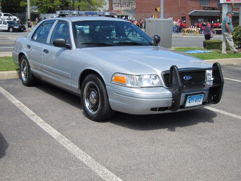 1991 Ford LTD Crown Victoria - silver Ford Crown Victoria police cruiser with front push bar and Connecticut plate parked at an outdoor event.