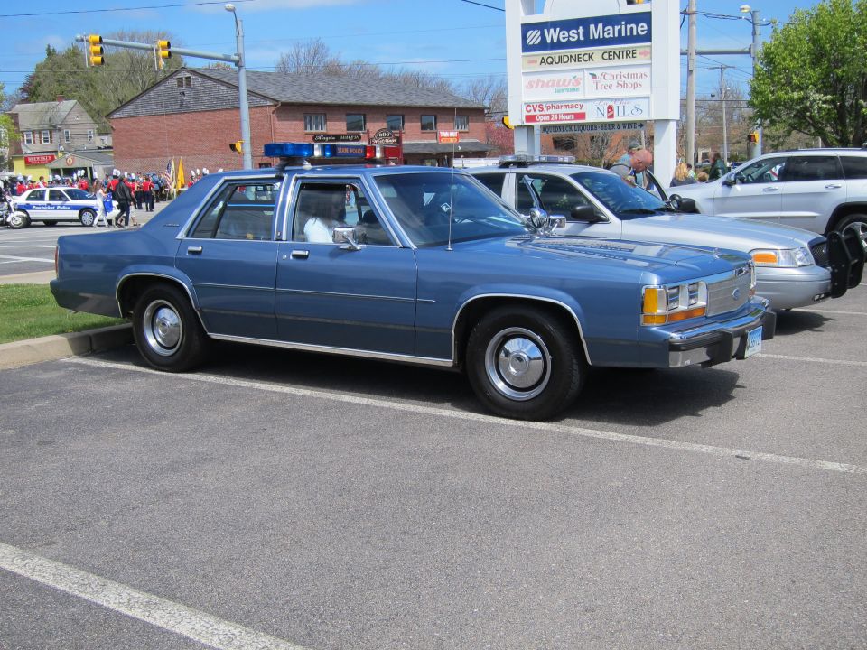 Blue Ford LTD Crown Victoria police sedan with light bar near West Marine