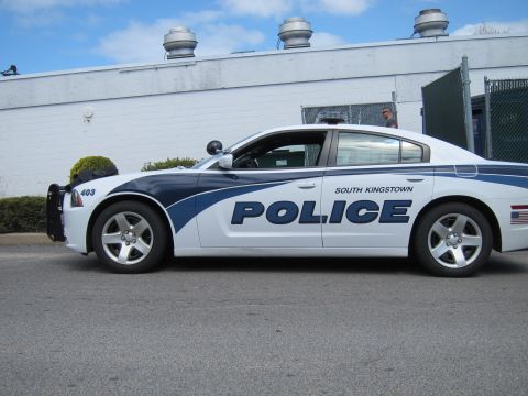 1991 Ford LTD Crown Victoria - white and blue Dodge Charger marked South Kingstown Police, unit 403, photographed from the driver side in front of a white building.