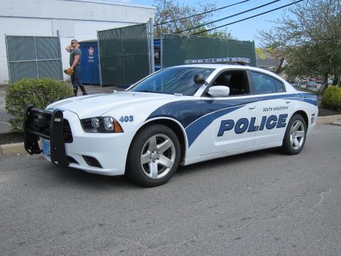 1991 Ford LTD Crown Victoria - white and blue Dodge Charger marked South Kingstown Police, unit 403, with front push bar, shown front-three-quarter.