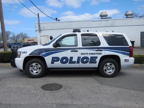 1991 Ford LTD Crown Victoria - white and blue Chevrolet Tahoe marked South Kingstown Police, unit 453, parked in profile by a white building.