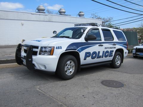 1991 Ford LTD Crown Victoria - white and blue Chevrolet Tahoe marked South Kingstown Police, unit 453, with front push bar, shown front-three-quarter.