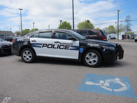 1991 Ford LTD Crown Victoria - black and white Ford Taurus marked Barrington Police parked in profile in a lot, with a handicap symbol on the pavement.
