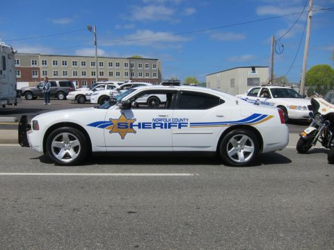 1991 Ford LTD Crown Victoria - white Dodge Charger marked Norfolk County Sheriff, unit 8, parked in profile beside a police motorcycle on a street.