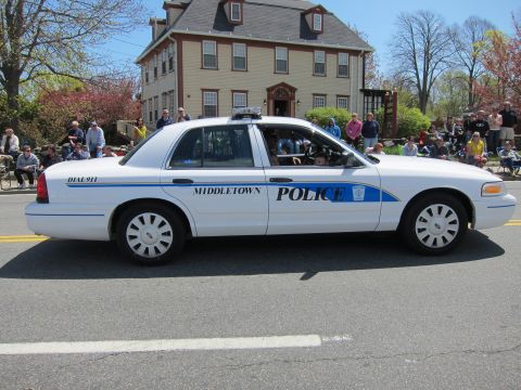 1991 Ford LTD Crown Victoria - white Ford Crown Victoria marked Middletown Police sits on a street in front of a gray colonial-style house.