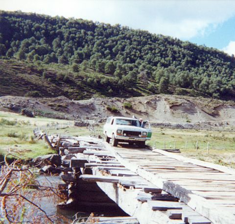 1979 Ford Bronco - White 1978 Ford Bronco carefully navigates a rustic wooden bridge in a rural landscape.