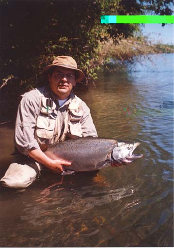 1979 Ford Bronco - A fisherman proudly displays a large salmon he has caught in a river.