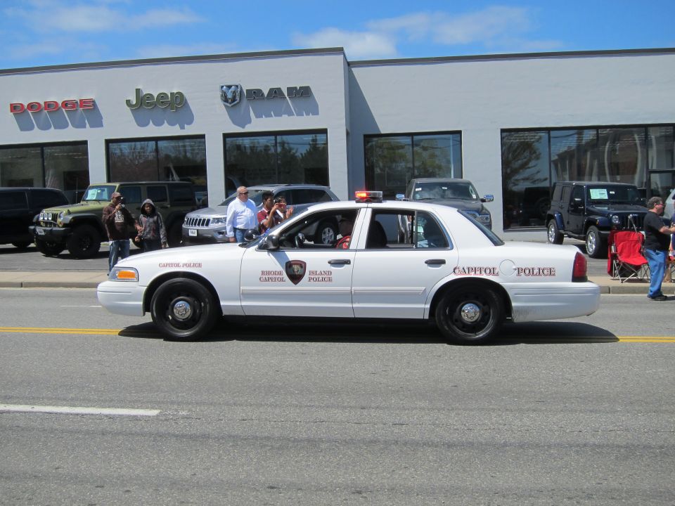 White Crown Victoria Capitol Police car in front of a Dodge Jeep RAM dealership