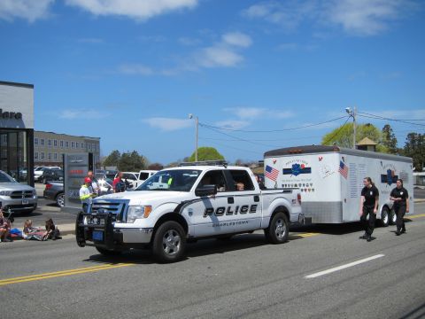 1991 Ford LTD Crown Victoria - white Charlestown Police Ford pickup tows an enclosed flag-decorated trailer with officers walking alongside.