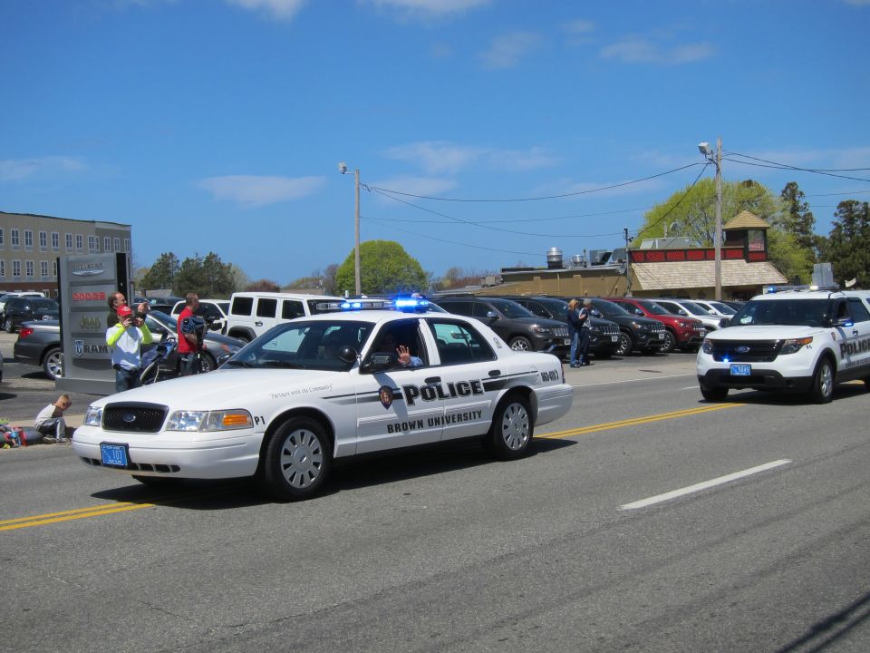 White Ford Crown Victoria marked Brown University Police with a Ford Explorer behind