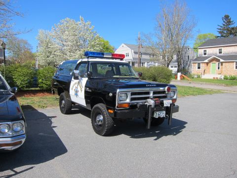 1991 Ford LTD Crown Victoria - black and white Dodge Ramcharger 4x4 with Highway Patrol markings, roof lights and a front winch parked in a residential driveway.
